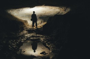 man-exploring-dark-cave-underground-tunnel-UQ3V8GJ-min